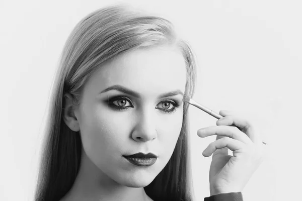 Model trägt Lidschatten mit Make-up-Pinsel auf — Stockfoto