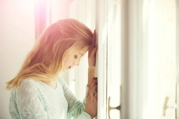 Menina bonita encostada contra a moldura da janela — Fotografia de Stock