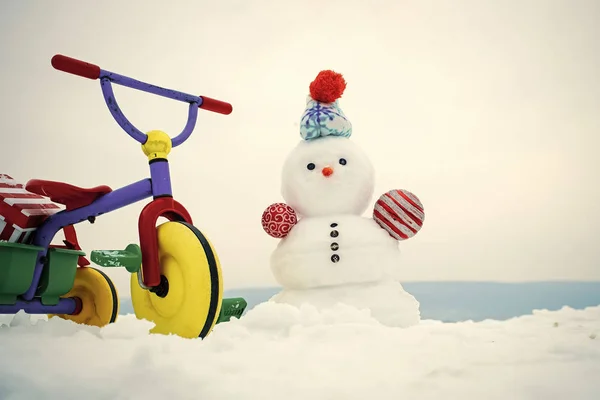 Tricikli és hóember a behavazott háttér — Stock Fotó