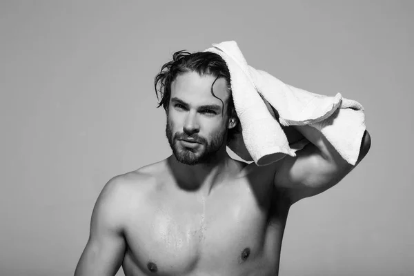 man with muscular wet body hold towel in bath