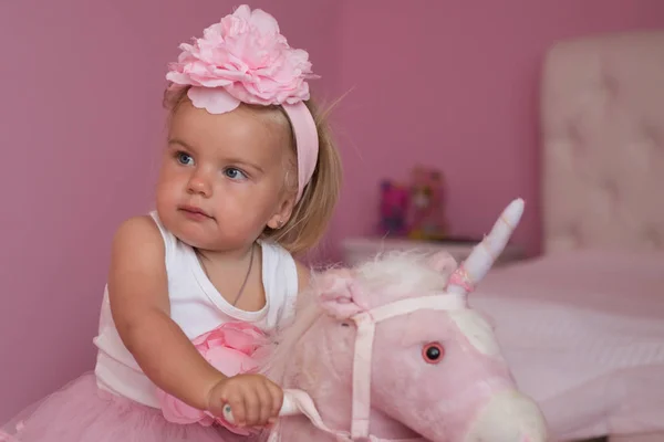 Me and my horse. Small child wear hair band. Small blond girl ride toy horse. Little girl with long hairstyle. Hair accessory. Toddler hairstyle for girls. Easy baby style