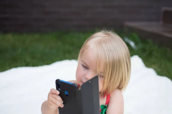 Excellente capacité de communication. Petite fille avec téléphone portable. Enfant fille aux cheveux blonds parler sur téléphone portable. Nouvelles technologies pour les enfants. Un petit enfant passe un coup de fil. Mes cheveux mon regard — Photo