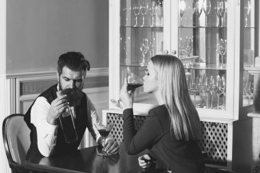 Erkek ve kadın bir restoranda kırmızı şarap paylaşımı