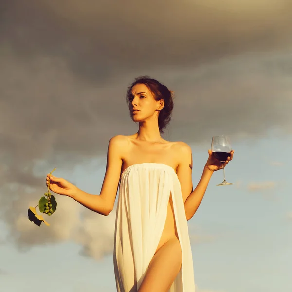 Hübsches Mädchen mit Weinglas und Trauben über dem Himmel — Stockfoto