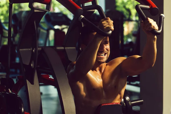 Musculoso hombre entrenamiento en gimnasio —  Fotos de Stock