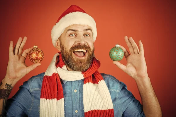 Kerst man houden xmas ballen op rode achtergrond — Stockfoto