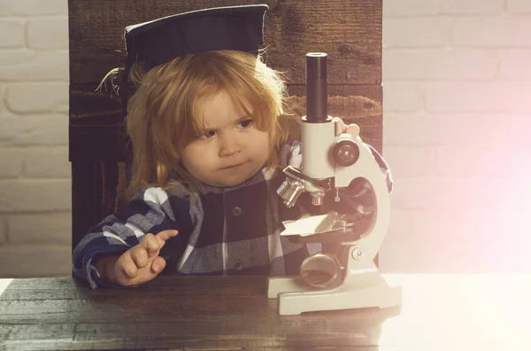 Kicsi fiú, tudós gyermek ballagási kalap, Mikroszkóp — Stock Fotó
