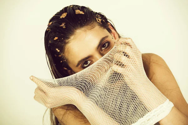 girl covering face behind fishnet stocking