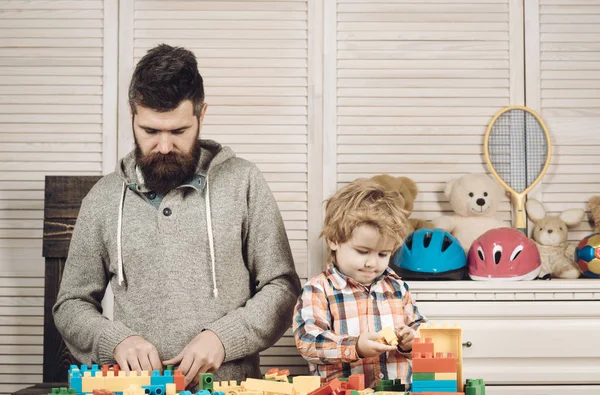 Un niño pequeño junto con su padre. feliz día de la familia y los niños. Feliz infancia. Cuidado y desarrollo. Un niño pequeño juega con su padre en casa. padre e hijo pequeño juegan con constructor. Mi familia. —  Fotos de Stock