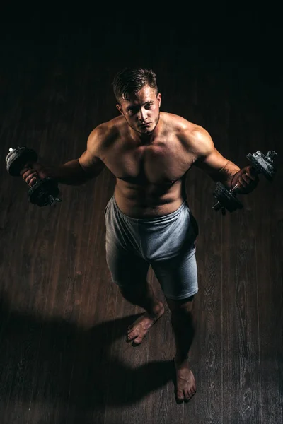 Η βελτίωση και όλο και ισχυρότερη. Μυώδης άνδρας έχουν προπόνηση στο γυμναστήριο. Ο άνθρωπος σε ασκήσεις με Βάρη αλτήρων. Εργαζόμενος άνθρωπος με fit μυώδες σώμα. Ισχυρή εργαζόμενος με έξι pack abs. Fitness και την κατάρτιση των μυών — Φωτογραφία Αρχείου