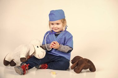 Doktor veteriner oyuncak hayvan ile oynarken tek tip çocuk