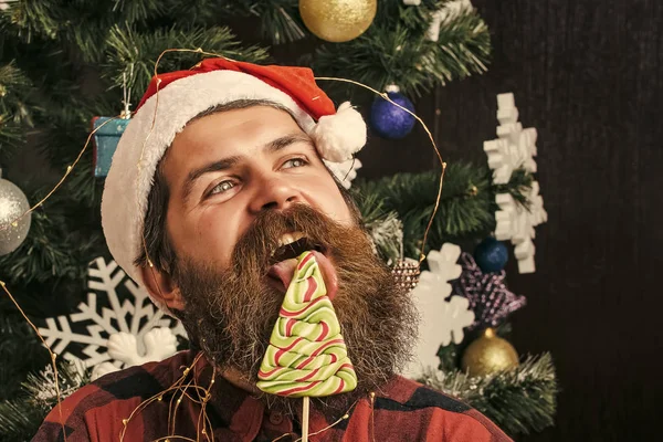 Kerst man met baard op gelukkig gezicht en lolly. — Stockfoto