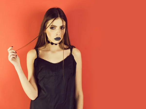 Hermosa mujer de moda en vestido negro sobre fondo rojo — Foto de Stock