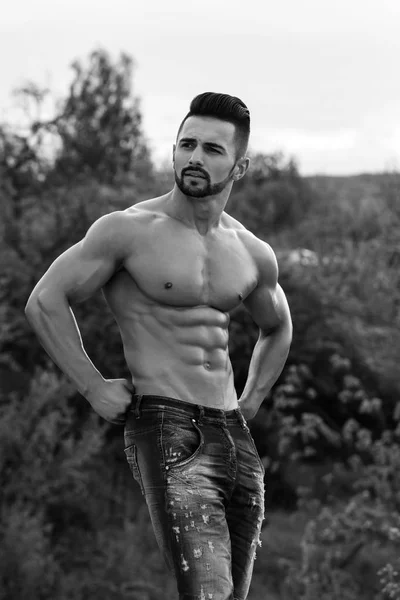 Hombre con cuerpo muscular sobre fondo natural —  Fotos de Stock