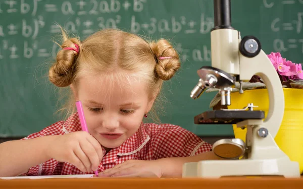 Kız öğrenci olun ders bilim deneme. Küçük kız okul laboratuvar mikroskop ile bilimsel deney çalıştırmak — Stok fotoğraf