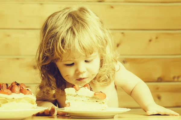 Kleine jongen eet aardbeien cake — Stockfoto