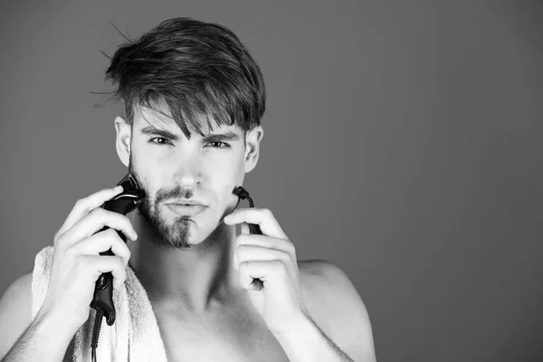 Mladý muž vlasy obličej holení s holicí strojek a elektrický holící strojek — Stock fotografie