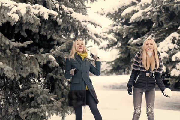 Glada tjejer spelar snöbollar vinterdag — Stockfoto