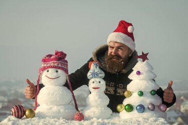 Noel Baba adam ile karlı heykeller göz kırpıyor