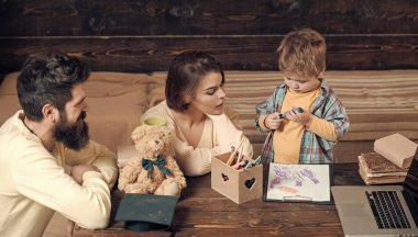 Anne oğlu, ahşap duvar arka plan öğretir. Çocuk Anne ve babamla dikkat dinliyor. Evde eğitim kavramı. Ebeveynler öğretim çocuk, konuşma. Aile eğitimi oğulları hakkında umurunda değil..