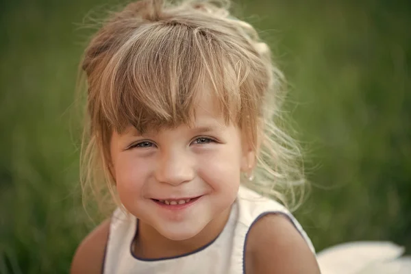 Menina com cabelo loiro sorriso na grama verde — Fotografia de Stock