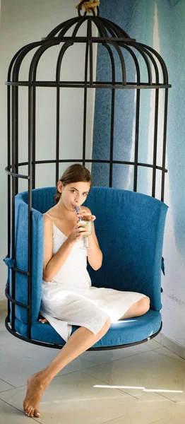 woman relax in cage chair at home. matcha tea ceremony of girl in cage chair. perfect morning with coffee. pretty woman drink japanese tea in iron cage. Enjoying beautiful morning. Coffee in chair