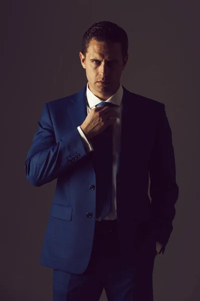Erfolgreicher Mann, der Krawatte im eleganten blauen formalen Anzug anpasst — Stockfoto