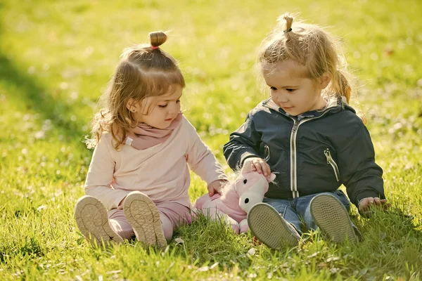 Fille et garçon assis sur l'herbe verte — Photo