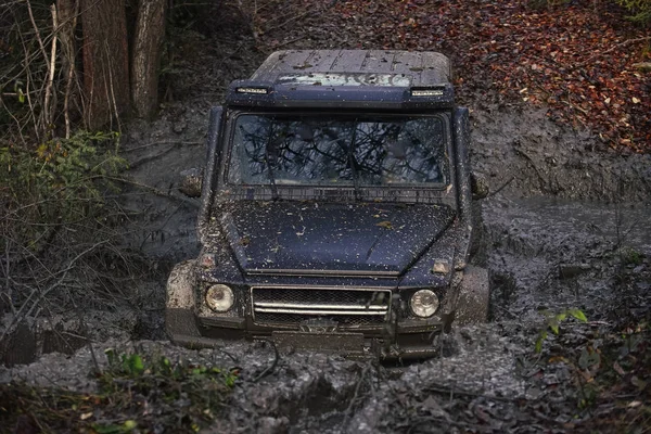 SUV dans une flaque d'eau faisant éclaboussures de boue . — Photo