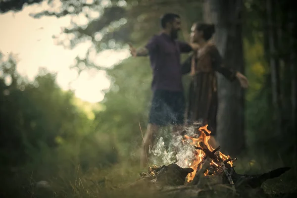 Couple in love hug on blurred background at campfire
