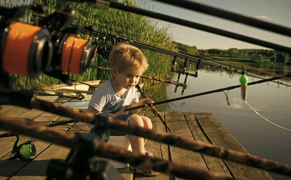 Очаровательный маленький мальчик рыбачит с деревянного причала на озере — стоковое фото