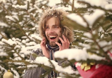 Köknar ağaçları karlı niteliğine gülümseyen adam