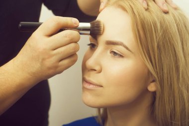 El ile toz kız yüzünü uygulayarak makyaj fırça