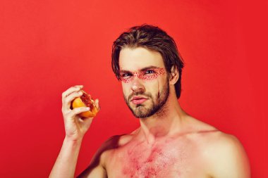 bir adam, elinde bir sulu greyfurt yarısı vitamini