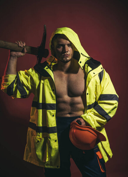 Temporary under construction. Construction worker or man miner with mining equipment. Muscular man worker. Hard worker with muscular torso. Mining area under construction