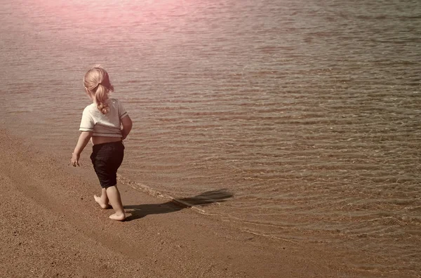 熱帯のビーチで t シャツと短パン散歩の少年 — ストック写真