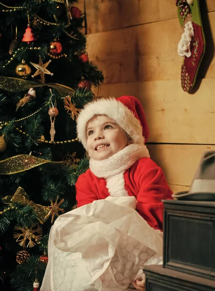 O miúdo do Pai Natal na árvore de Natal. Celebração de festa de Natal. A menina pequena de Ano Novo em chapéu. Férias de inverno e férias. Criança feliz de Natal com — Fotografia de Stock