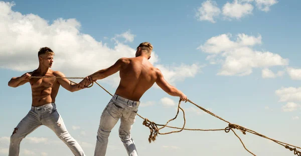 Het behandelen van uw team als een familie. Sterke mannen trekken touwen. Atletische tweeling met fit sexy lichaam. Twins mannen gebruiken gespierde hand sterkte. Sport oefeningen voor het bouwen van kracht en macht — Stockfoto