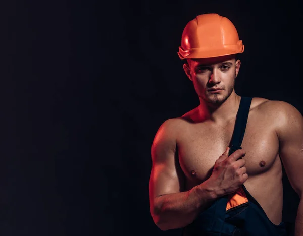 Construimos bases sólidas. Obrero guapo o obrero. El hombre musculoso usa sombrero duro y uniforme. Hombre trabajador con musculoso sexy cuerpo. Trabajador de la construcción o constructor. Espacio de copia seguro y fuerte — Foto de Stock