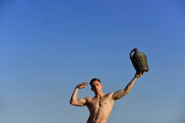 Forte e saudável. Homem musculoso com garrafa de vinho vintage se divertir no verão. Homem atlético com corpo muscular relaxar no dia de verão. Uma vindima de vinho é o ano em que as uvas foram colhidas, espaço de cópia — Fotografia de Stock