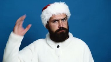 Mavi bir arka plan üzerine bir yeni yıl kırmızı şapka sakallı bir adam. Yeni yıl kutlamaları kavramı.