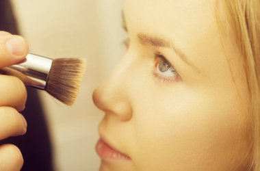 kız makyaj fırçası ile yüz cilt üzerinde toz alma