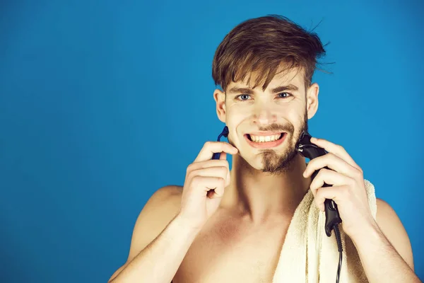 Rosto do homem sorridente barbear o cabelo com barbeador elétrico e navalha de segurança — Fotografia de Stock