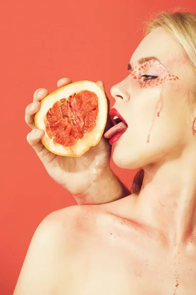 Frau mit kreativem modischem Make-up lecken Grapefruit, Vitamin — Stockfoto
