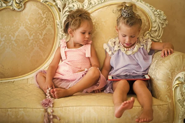 Дитячі дівчата сидять на класичному дивані — стокове фото