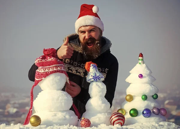 Babbo Natale uomo mettere cappello sul pupazzo di neve e mostrando gesto ok — Foto Stock