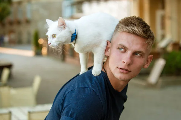 Willen weten over alles. Kat staat op achterkant van zijn eigenaar. Gelukkig man op wandeling met huisdier kat. Gespierde man houd schattig stamboom kat. Gelukkig kat eigenaar met gespierde look — Stockfoto