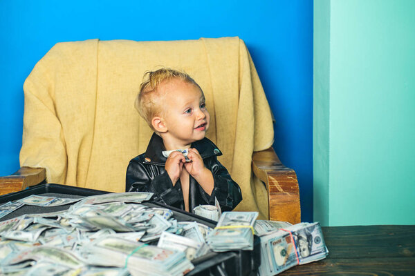 Принимать денежные решения. Маленький предприниматель работает в офисе. Мальчик с чемоданом денег. Мальчик считает деньги наличными. Маленький ребенок ведет бухгалтерский учет в стартап-компании. Затраты на запуск бизнеса
