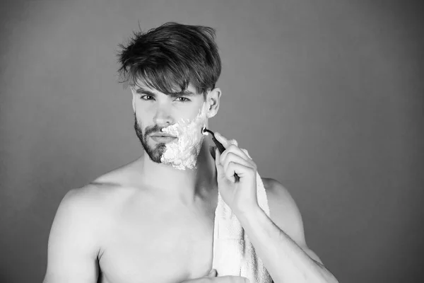 Macho guapo con barba de afeitar en el pecho desnuda con afeitadora de seguridad — Foto de Stock