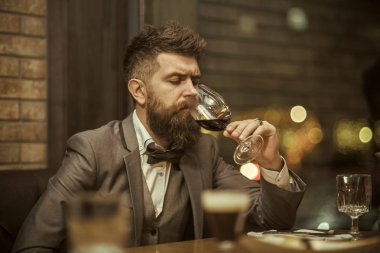 Kırmızı şarap, adam bardaktaki şarabın rengini ölçer. Sommelier kırmızı şarabı tadıyor.